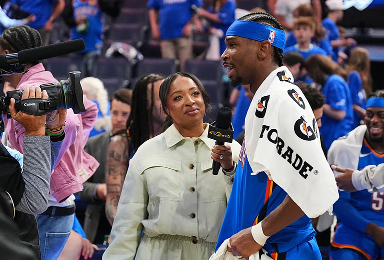 Oklahoma City Thunder guard Shai Gilgeous-Alexander, right, gives a broadcast interview after the team's Game 1 in a second-round NBA basketball playoffs series against the Los Angeles Lakers in Oklahoma City. - | Photo: AP/Kyle Phillips