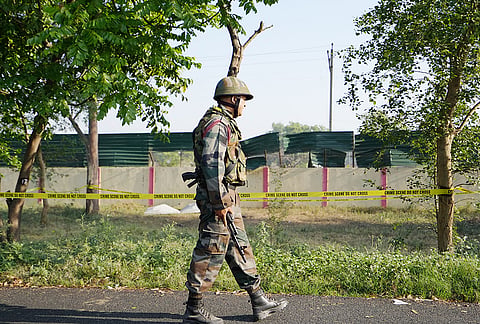 A security personnel keeps vigil near the blast site close to the Army cantonment area in Khasa, in Amritsar. Preliminary investigation suggested that an object was hurled towards the boundary wall, triggering the blast, police said. 