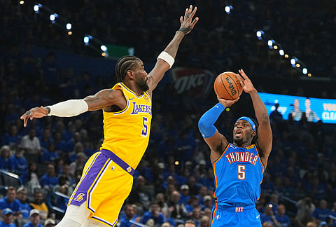 Oklahoma City Thunder guard Luguentz Dort, right, shoots as Los Angeles Lakers' Deandre Ayton, left, defends in the second half of Game 1 in a second-round NBA basketball playoffs series in Oklahoma City. 