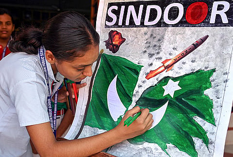 A school student paints a poster depicting 'Operation Sindoor' ahead of its anniversary, in Bikaner.