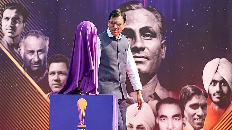 Union Minister for Sports Mansukh Mandaviya walks past the covered Men's Junior Hockey World Cup trophy during the Hockey India centenary celebrations, at Major Dhyan Chand National Stadium, in New Delhi. - | Photo: PTI/Atul Yadav