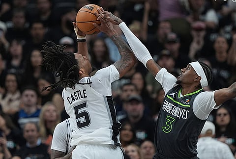 San Antonio Spurs guard Stephon Castle (5) is fouled by Minnesota Timberwolves forward Jaden McDaniels (3) during the first half in Game 2 of a second-round NBA playoffs basketball series in San Antonio.