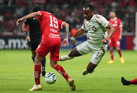 Jeremy Ebobisse of the United States' Los Angeles FC, right, and Simon Santiago of Mexico's Toluca compete for the ball during a CONCACAF Champions Cup second leg semifinal soccer match in Toluca, Mexico.