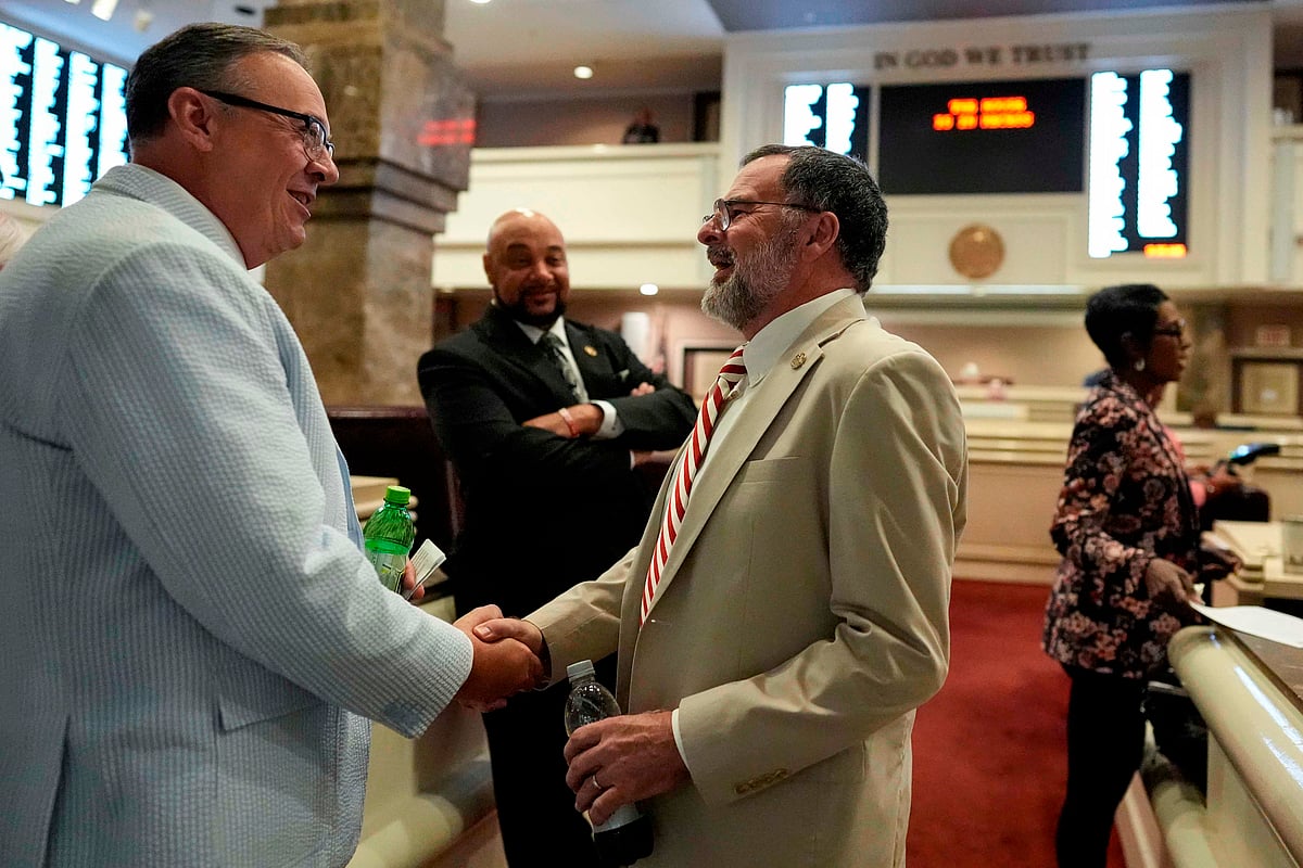 Republican state Rep. Chris Pringle, centre, speaks to a colleague on the House floor during a special session of the Alabama Legislature. - PTI