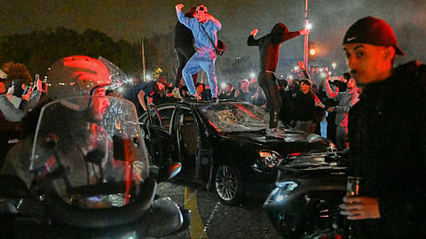 People smash a car as they celebrate Paris Saint-Germain's Champions League semifinal victory over Bayern Munich at Place de la Concorde in Paris, Thursday, May 7, 2026.
