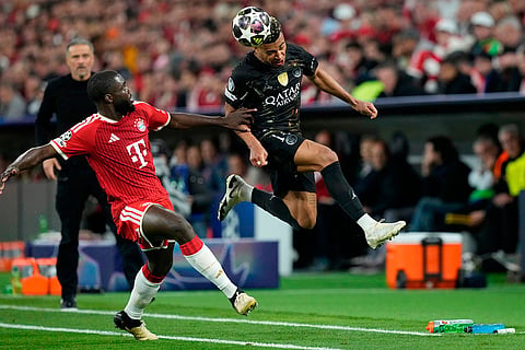 PSG's Desire Doue, right, heads the ball as Bayern's Dayot Upamecano tries to stop him during the Champions League semifinal second leg soccer match between Bayern Munich and Paris Saint Germain in Munich, Germany.
