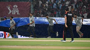 AP : LSG vs RCB, IPL 2026: Ground staff pull rain covers to the field as it drizzles during the Indian Premier League cricket match.