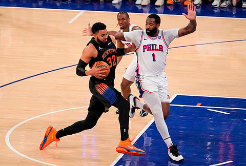 New York Knicks center Karl-Anthony Towns (32) drives past Philadelphia 76ers center Andre Drummond (1) during the first half of Game 2 in a second-round NBA basketball playoffs series, in New York. 