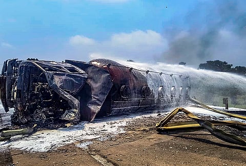 Water is sprayed on a gas tanker after it overturned and caught fire on Gawai Barrage, in Bokaro district, Jharkhand.