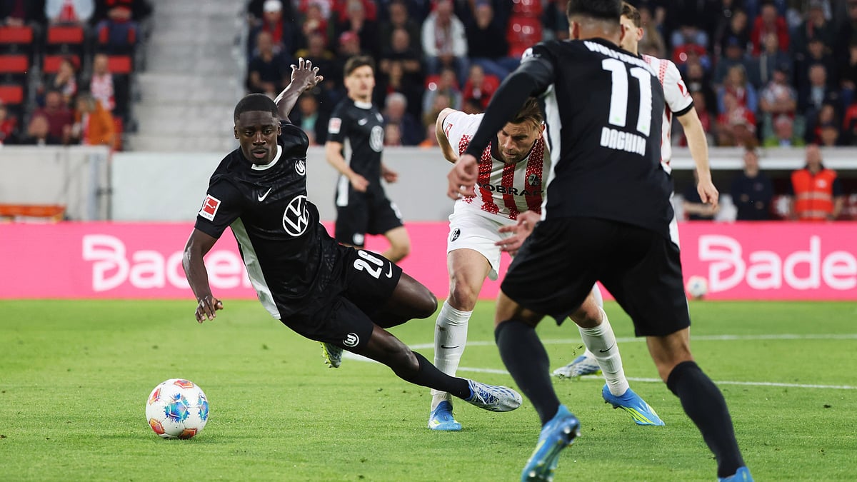 Wolfsburg Saël Kumbedi, left, and Freiburg's Lucas Höler, centre, challenge for the ball during the German Bundesliga soccer match between SC Freiburg and VfL Wolfsburg in Freiburg im Breisgau, Germany, Sunday, May 3, 2026.  - | Photo: dpa/Philipp von Ditfurth via AP
