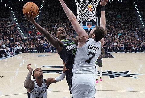 Minnesota Timberwolves guard Anthony Edwards (5) drives to the basket aginst San Antonio Spurs center Luke Kornet (7) during the first half in Game 2 of a second-round NBA playoffs basketball series in San Antonio.