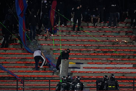 Fans of Colombia's Independiente Medellin shine laser pointers toward the field as the match against Brazil's Flamengo was temporarily suspended because of crowd trouble during a Copa Libertadores Group A soccer match in Medellin, Colombia.