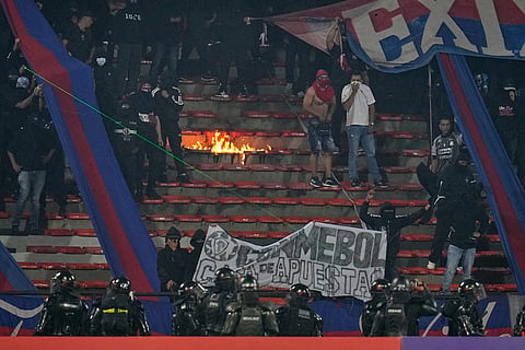 Fans of Colombia's Independiente Medellin stand in the grandstands after the match against Brazil's Flamengo was temporarily suspended because of crowd trouble during a Copa Libertadores Group A soccer match in Medellin, Colombia.