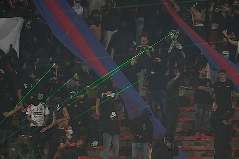 Fans of Colombia's Independiente Medellin shine laser pointers toward the field as the match against Brazil's Flamengo was temporarily suspended because of crowd trouble during a Copa Libertadores Group A soccer match in Medellin, Colombia.