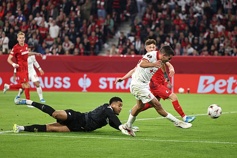 Braga's Victor Gómez shoots at the goal next to Freiburg goalkeeper Noah Atubolu during the Europa League second leg semifinal soccer match between SC Freiburg  and SC Braga in Freiburg, Germany.