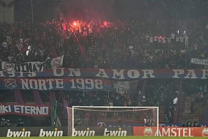 | Photo: AP/Fernando Vergara : Fans of Colombia's Independiente Medellin light flares as the match against Brazil's Flamengo was temporarily suspended because of crowd trouble during a Copa Libertadores Group A soccer match in Medellin, Colombia.
