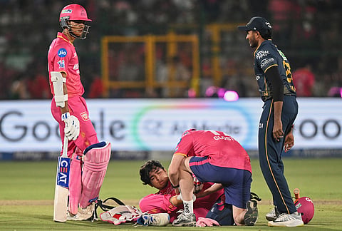 A physio attends Rajasthan Royals' Vaibhav Sooryavanshi as he lies on the ground after getting injured during the Indian Premier League cricket match between Rajasthan Royals and Gujarat Titans in Jaipur.
