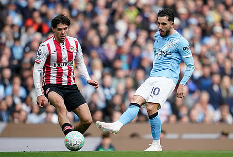 Brentford's Aaron Hickey, left, tries to block a shot from Manchester City's Rayan Cherki during the English Premier League soccer match between Manchester City and Brentford in Manchester.