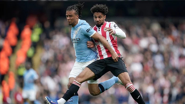 Nathan Ake, left, and Kevin Schade challenge for the ball during the English Premier League match between Manchester City and Brentford in Manchester. - Photo: AP/Dave Thompson