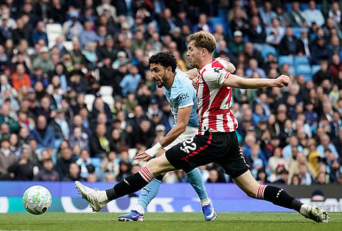 Manchester City's Omar Marmoush, left, scores his side's third goal during the English Premier League soccer match between Manchester City and Brentford in Manchester.