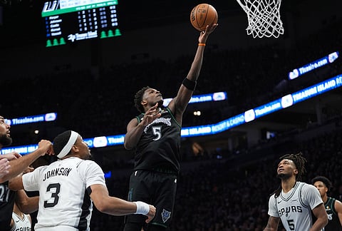 Minnesota Timberwolves guard Anthony Edwards (5) drives to the basket between San Antonio Spurs forward Keldon Johnson (3) and guard Stephon Castle (5) during the first half of Game 3 of a NBA basketball second-round playoff series in Minneapolis.