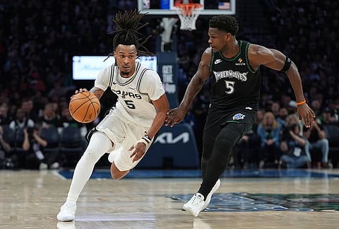 San Antonio Spurs guard Stephon Castle, left, drives against Minnesota Timberwolves guard Anthony Edwards, right, during the second half of Game 3 of a NBA basketball second-round playoff series in Minneapolis.