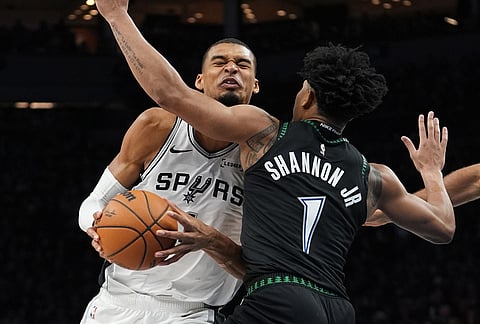 San Antonio Spurs forward Victor Wembanyama, left, is fouled by Minnesota Timberwolves guard Terrence Shannon Jr. (1) as he drives to the basket during the second half of Game 3 of a NBA basketball second-round playoff series in Minneapolis.