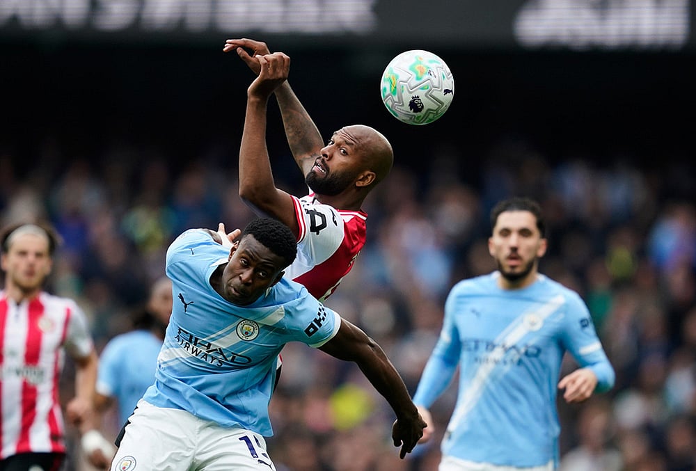Brentford's Igor Thiago, top, and Manchester City's Marc Guehi challenge for the ball during the English Premier League soccer match between Manchester City and Brentford in Manchester. - | Photo: AP/Dave Thompson