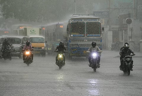 Commuters make their way during rainfall, in Chennai, Tamil Nadu.