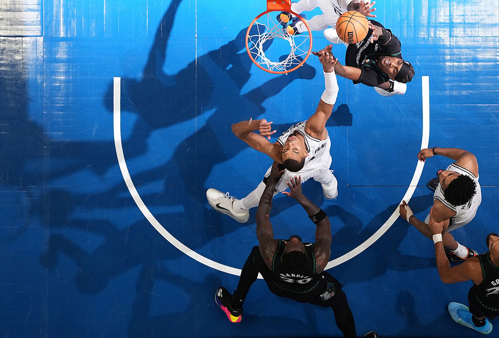 Minnesota Timberwolves forward Jaden McDaniels (3), top, shoots over San Antonio Spurs forward Victor Wembanyama (1), middle, during the second half of Game 3 of a NBA basketball second-round playoff series, in Minneapolis.  - | Photo: AP/Abbie Parr