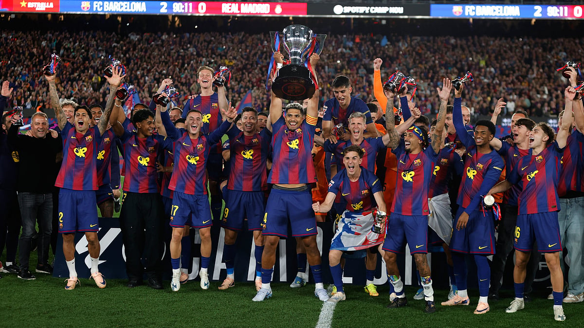 Barcelona players lift the trophy after winning the Spanish La Liga El Clasico match against Real Madrid to clinch the Spanish league title in Barcelona, Spain, Sunday. - AP Photo