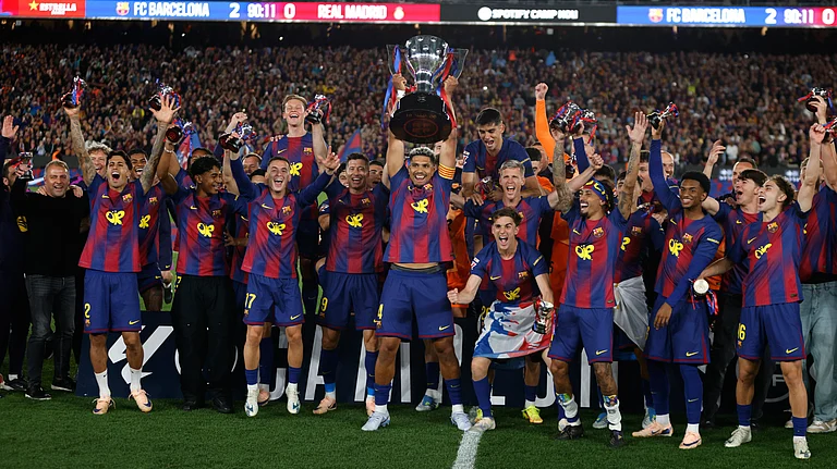 Barcelona players lift the trophy after winning the Spanish La Liga El Clasico match against Real Madrid to clinch the Spanish league title in Barcelona, Spain, Sunday. - AP Photo