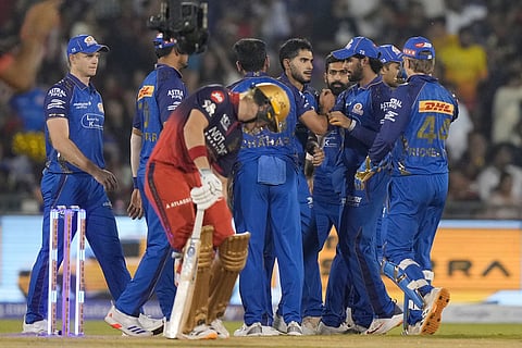 Mumbai Indians' Raj Angad Bawa, center, celebrate with teammates after taking the catch of Royal Challengers Bengaluru's Virat Kohli during the Indian Premier League cricket match between Royal Challengers Bengaluru and Mumbai Indians in Raipur, India.