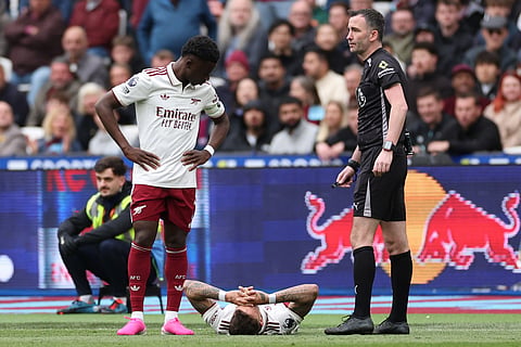 Arsenal's Ben White reacts to an injury during the Premier League soccer match between West Ham and Arsenal in London, Sunday.