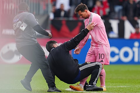 Security arrives to take a fan off the field after he ran on to meet Inter Miami CF midfielder Lionel Messi (10) during second half MLS soccer against Toronto FC, in Toronto.
