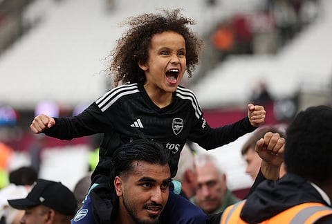 An Arsenal fan celebrate after the Premier League soccer match between West Ham and Arsenal in London.