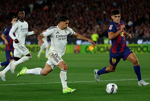 Real Madrid's Brahim Diaz fights for the ball against Barcelona's Gerard Martin during the Spanish La Liga soccer match between FC Barcelona and Real Madrid in Barcelona, Spain.