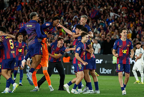 Barcelona players celebrate after winning the Spanish La Liga soccer match between FC Barcelona and Real Madrid that makes them Spanish league champions in Barcelona, Spain.