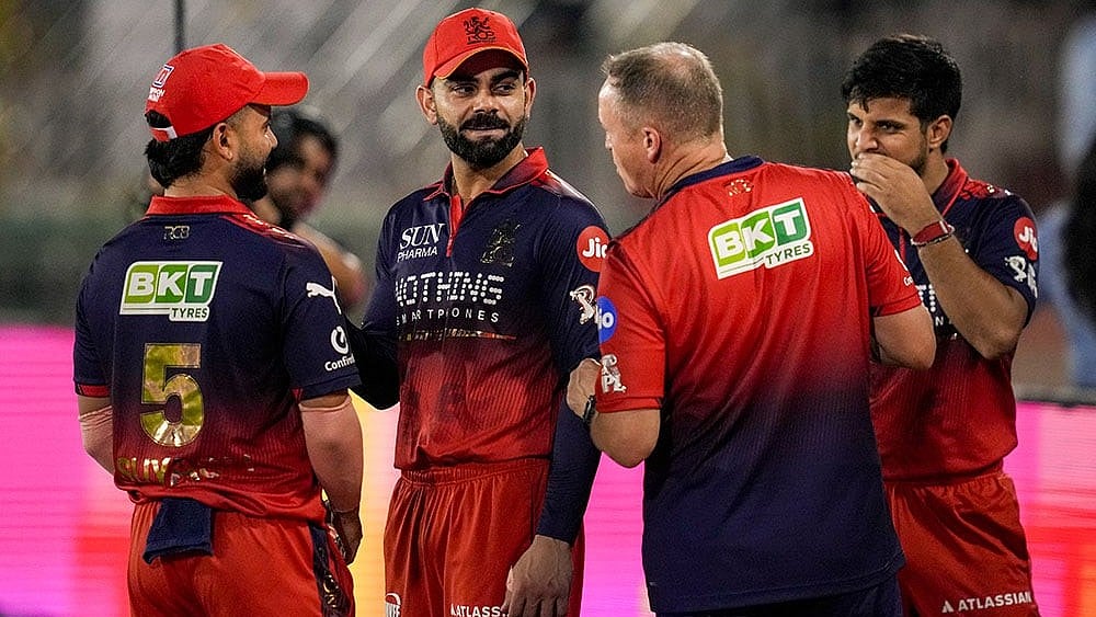 Raipur: Royal Challengers Bengaluru's Virat Kohli, centre, Suyash Sharma, left, and head coach Andy Flower, second left, during an Indian Premier League (IPL) 2026 T20 cricket match between Royal Challengers Bengaluru and Mumbai Indians, in Raipur, Chattisgarh. - | Photo: PTI/Atul Yadav