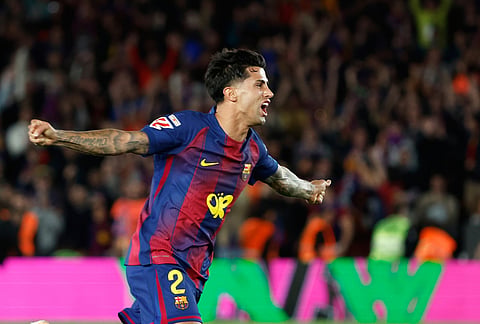 Barcelona's Joao Cancelo celebrates after winning the Spanish La Liga soccer match between FC Barcelona and Real Madrid that makes them Spanish league champions in Barcelona, Spain.