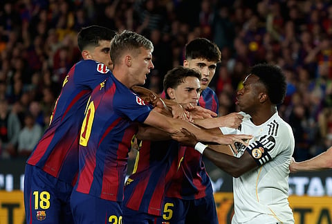 Real Madrid's Vinicius Junior argues with Barcelona players during the Spanish La Liga soccer match between FC Barcelona and Real Madrid in Barcelona, Spain.