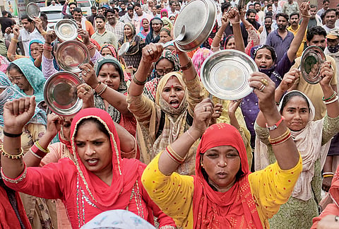 Municipal Corporation of Gurugram (MCG) workers clang utensils during a protest rally against the state government in support of their demands, in Gurugram, Haryana.
