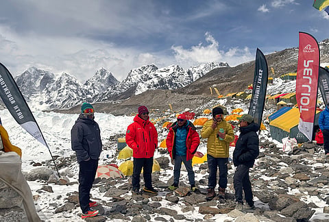 Guides and mountaineers stand outside their tents during acclimatization period before attempting the Mount Everest ascent at the base camp, Nepal.