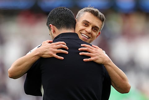 Arsenal's Leandro Trossard celebrates with Arsenal's manager Mikel Arteta after the Premier League soccer match between West Ham and Arsenal in London.