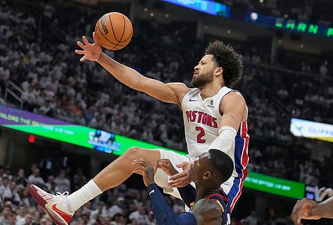 Detroit Pistons guard Cade Cunningham (2) loses control of the ball in front of Cleveland Cavaliers guard Dennis Schroder, front, in the second half of Game 3 of a second-round NBA playoffs basketball series in Cleveland. 
