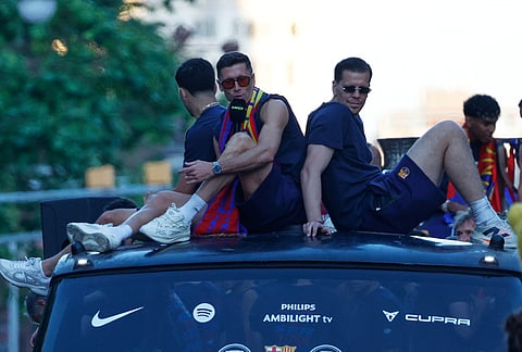 FC Barcelona players Wojciech Szczęsny, right, and Robert Lewandowski celebrate atop a bus after winning the Spanish La Liga title in Barcelona, Spain.