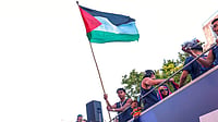 Lamine Yamal Waves Palestine Flag During Barcelona's La Liga Title Parade AP : FC Barcelona player Lamine Yamal holds a Palestinian flag as he celebrates with his team atop a bus after winning the Spanish La Liga title in Barcelona, Spain.