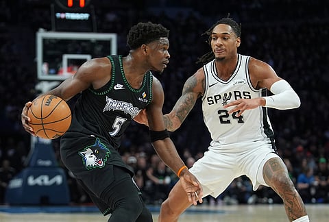 Minnesota Timberwolves guard Anthony Edwards (5) drives against San Antonio Spurs guard Devin Vassell (24) during the first half of Game 4 of an NBA basketball second-round playoffs series in Minneapolis.
