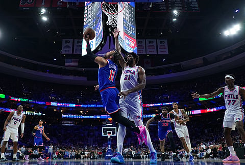 New York Knicks' Jalen Brunson, left, goes up for a shot against Philadelphia 76ers' Joel Embiid during the second half of Game 4 in a second-round NBA basketball playoffs series in Philadelphia.