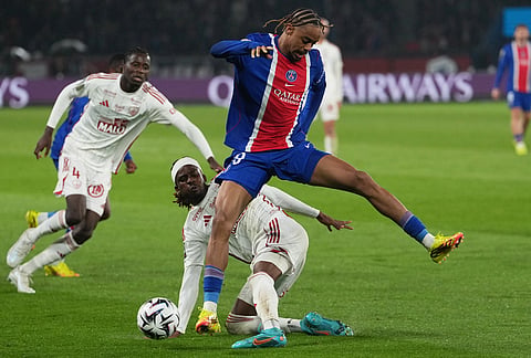 PSG's Bradley Barcola, top, is challenged by Brest's Daouda Guindo during the French League One soccer match between Paris Saint Germain and Brest in Paris, France.